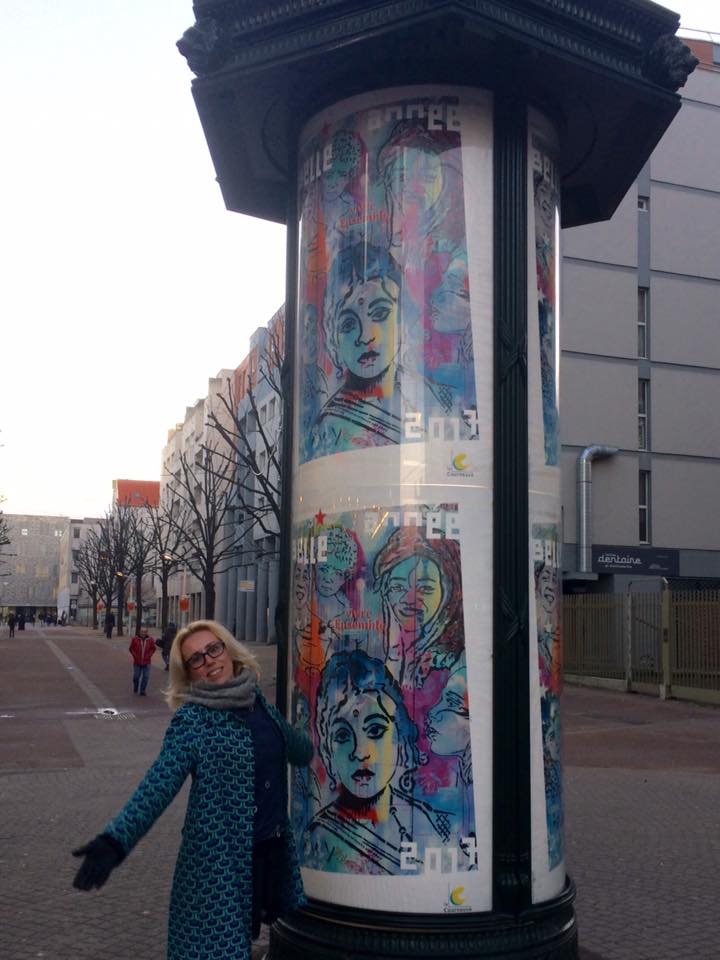 L’artiste IZA ZAro devant une colonne Morris et son oeuvre!